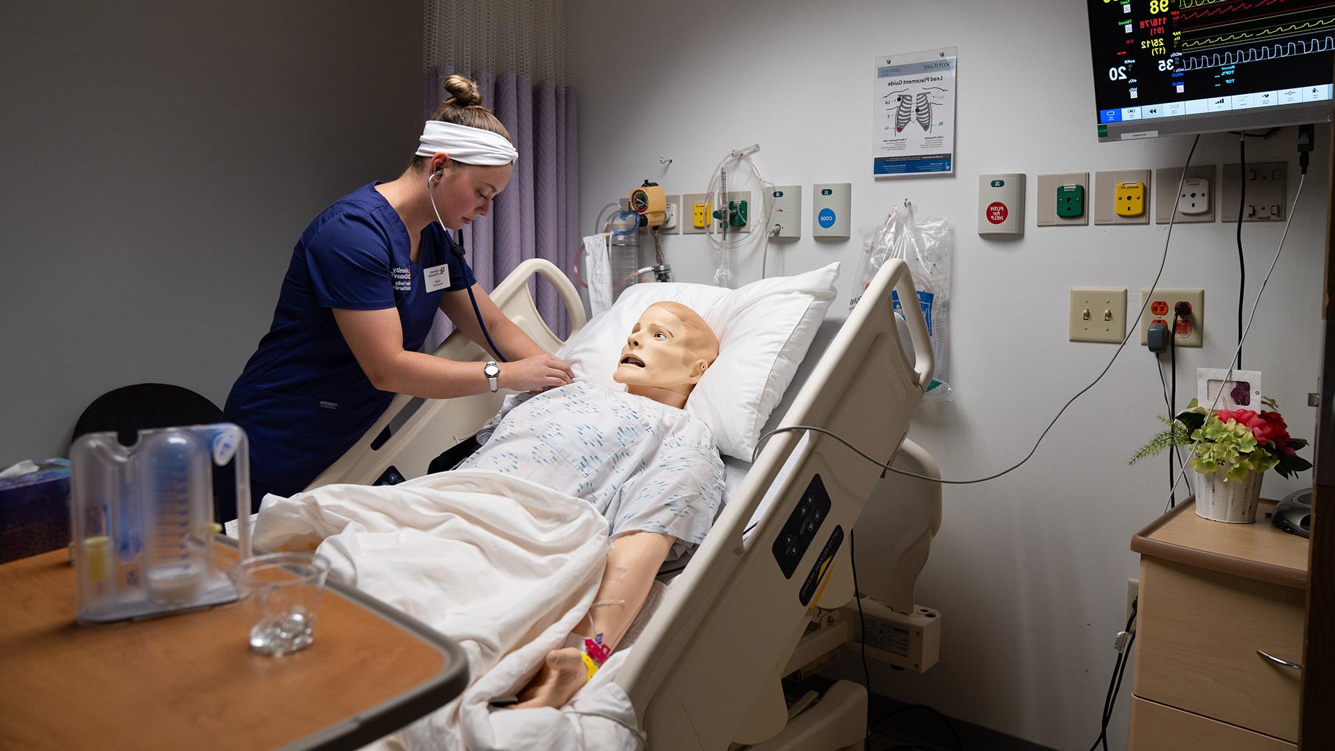 Nursing student in sim lab attending dummy